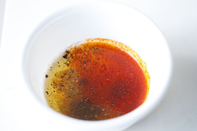 Bowl of colorful mixed spices with lemon juice to make dressing.