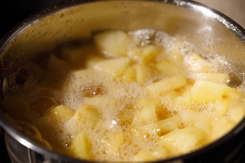 Apples cooking and simmering in pan.