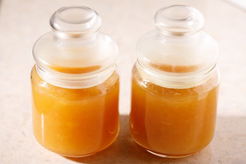 Apple jam filled in two glass jars and closed with lids.