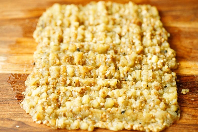 Mashed eggplant spread on wooden board.