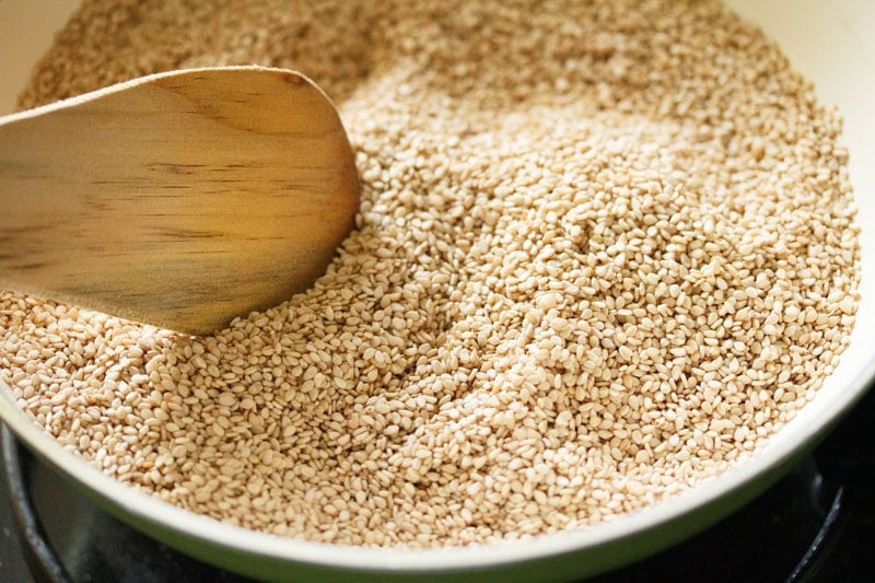 Toasting sesame seeds in a pan.