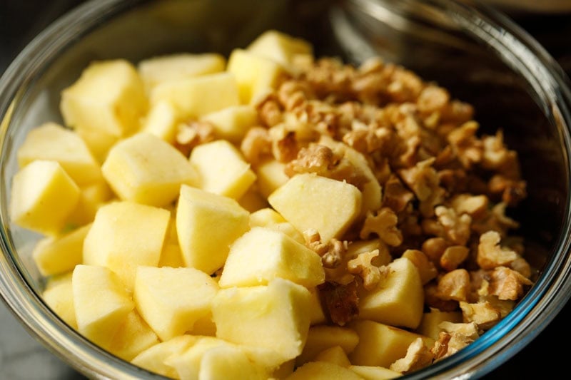 Chopped apples and walnuts in bowl.