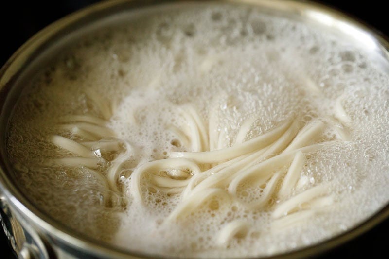 Udon noodles boiling in water.