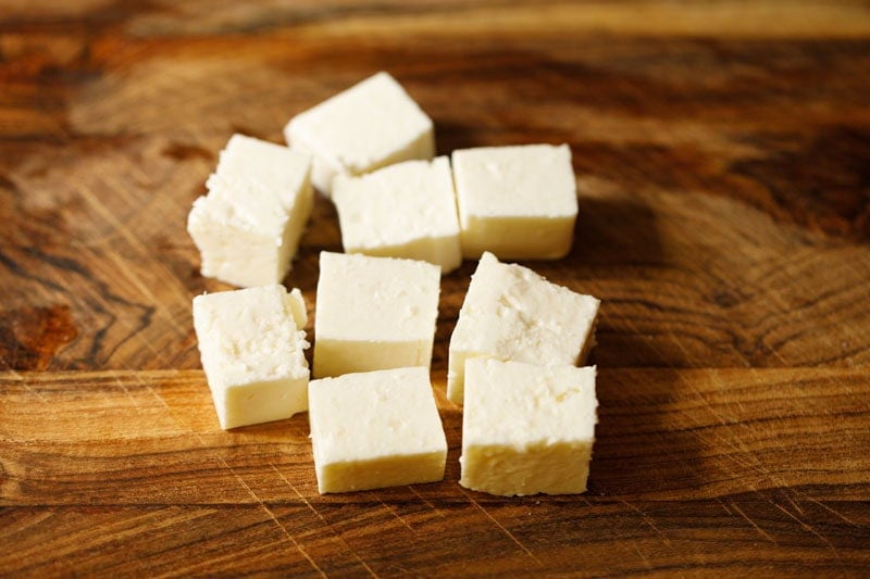 Cubes of white feta cheese on wood.