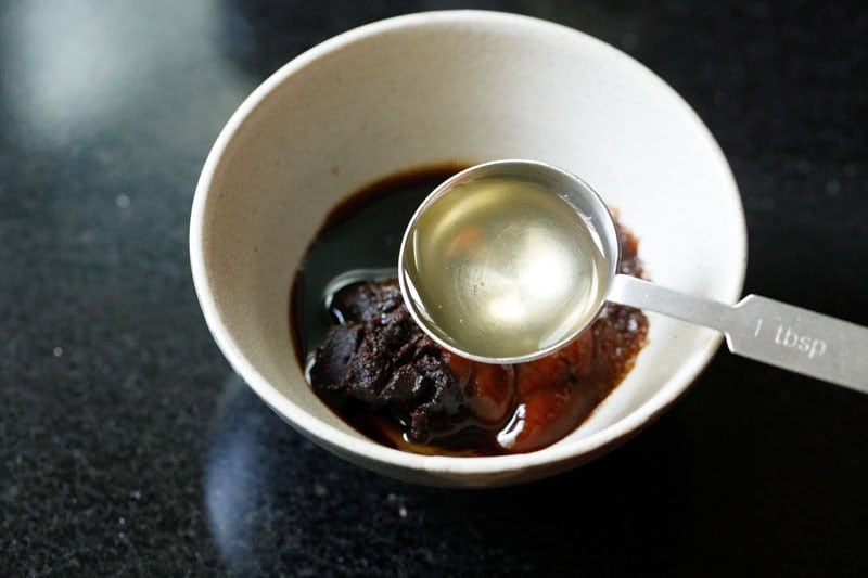 Bowl with sauce ingredients and spoon with mirin.