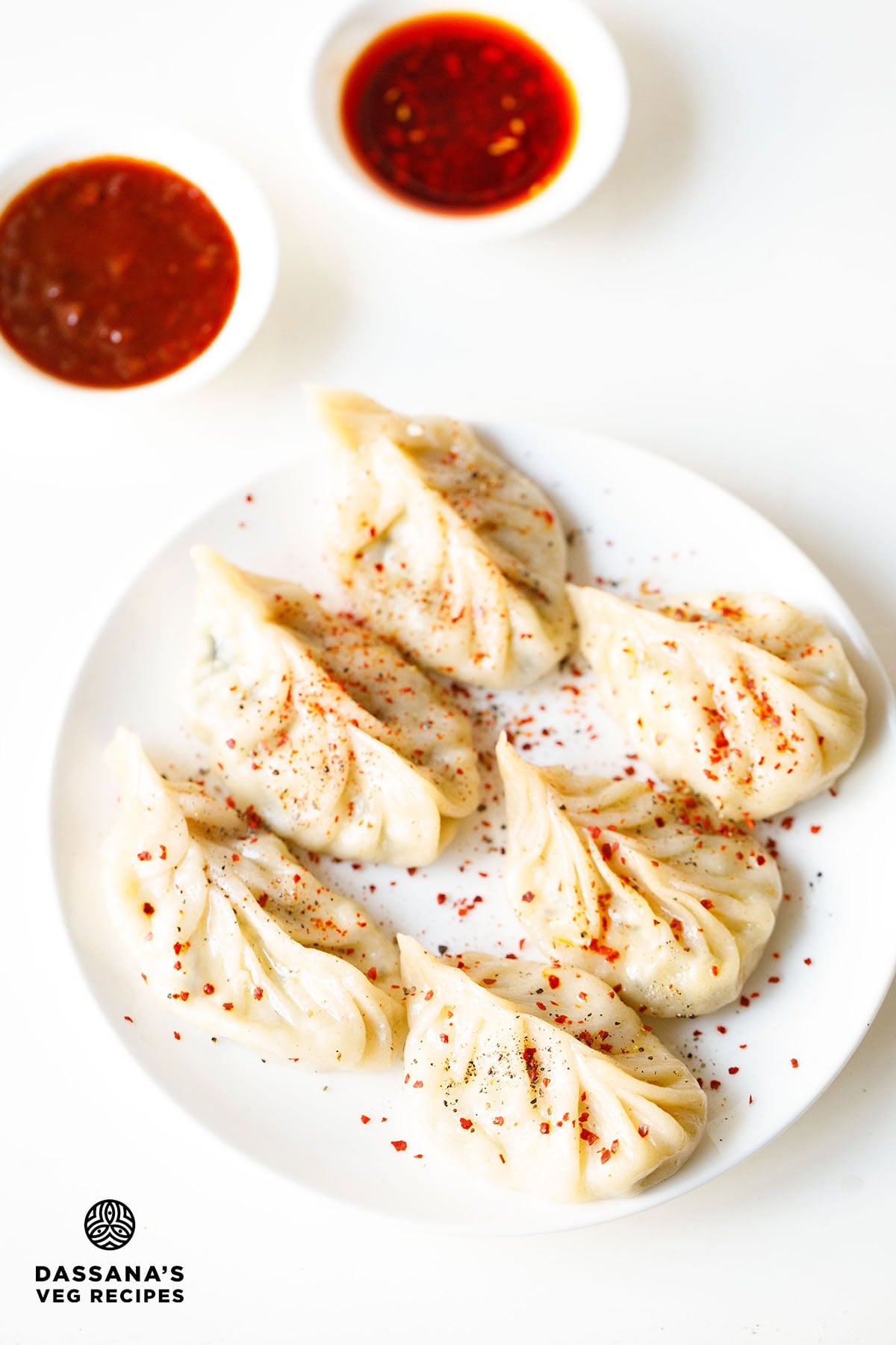 Steamed paneer momos with dipping sauces.