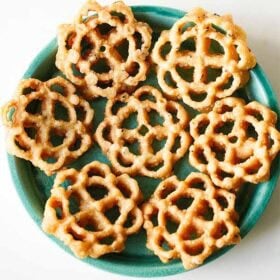 Decorative fried rose cookies or achappam on plate.