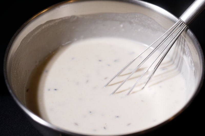 Flours, sugar and coconut milk mixed to make rose cookies batter.