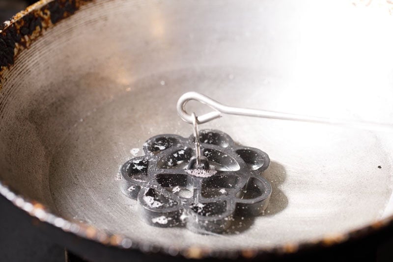 achappam mould in hot oil in kadai.