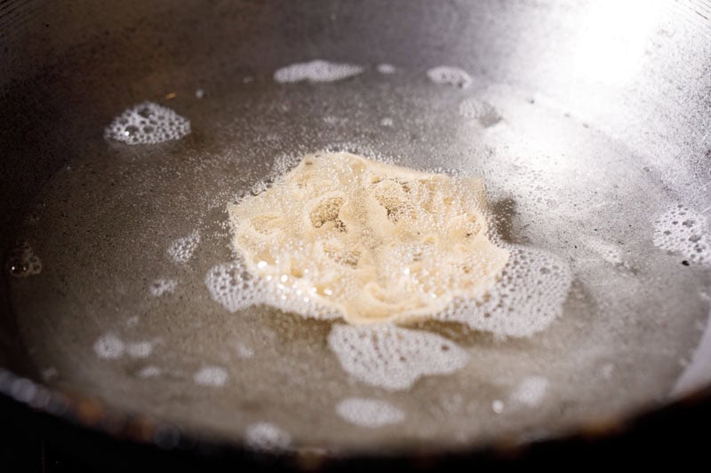 achappam or rose cookie frying in oil.