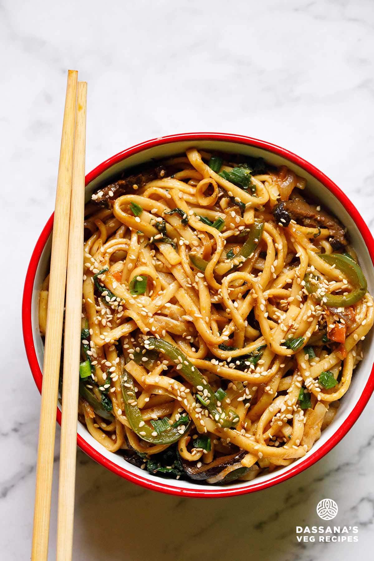 Bowl of stir-fried yaki udon noodles with chopsticks.