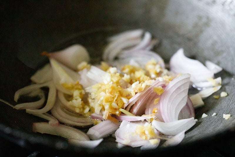 Sliced onions, ginger and garlic in a wok.