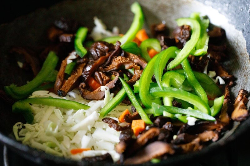 Vegetables amd shiitake mushrooms in wok.
