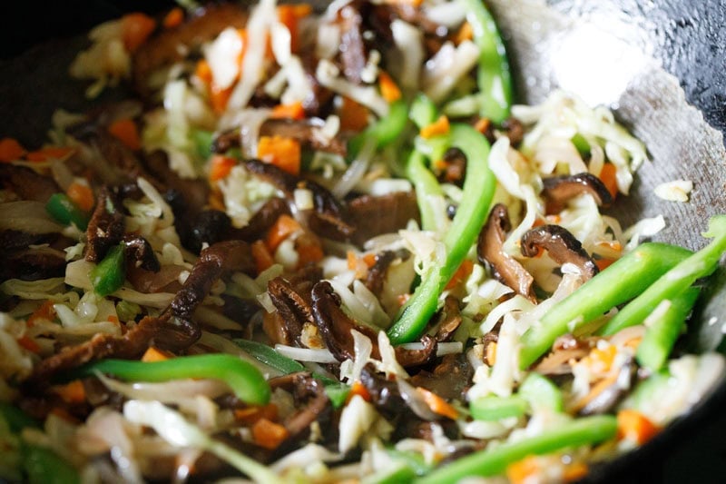 Stir-fried vegetables and shiitake in a wok.