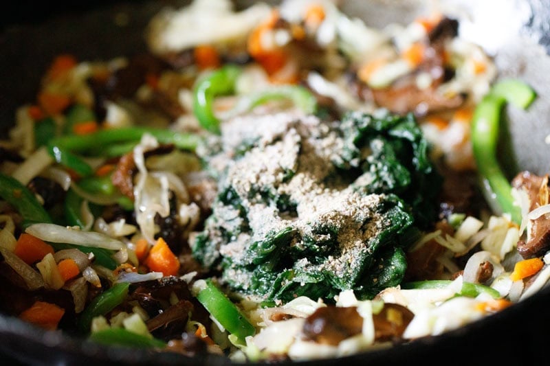 Vegetables and spinach in a wok.
