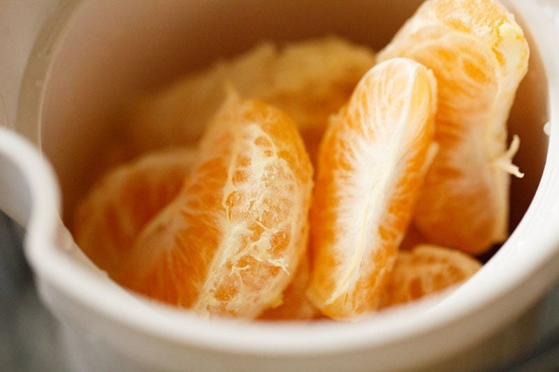 Segments of orange and sweet line in a juicer feeder.