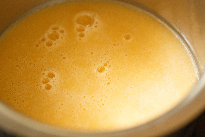 Smooth, frothy orange liquid in pan.