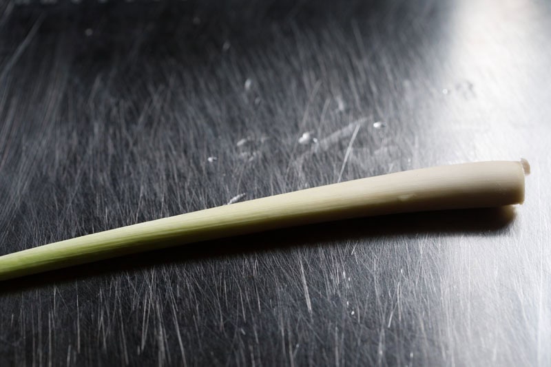 stalk of lemongrass on a steel chopping board.