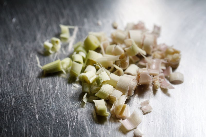 chopped lemongrass stalk on steel chopping board.