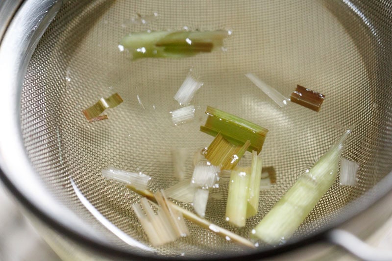 lemongrass tea being strained in a cup.