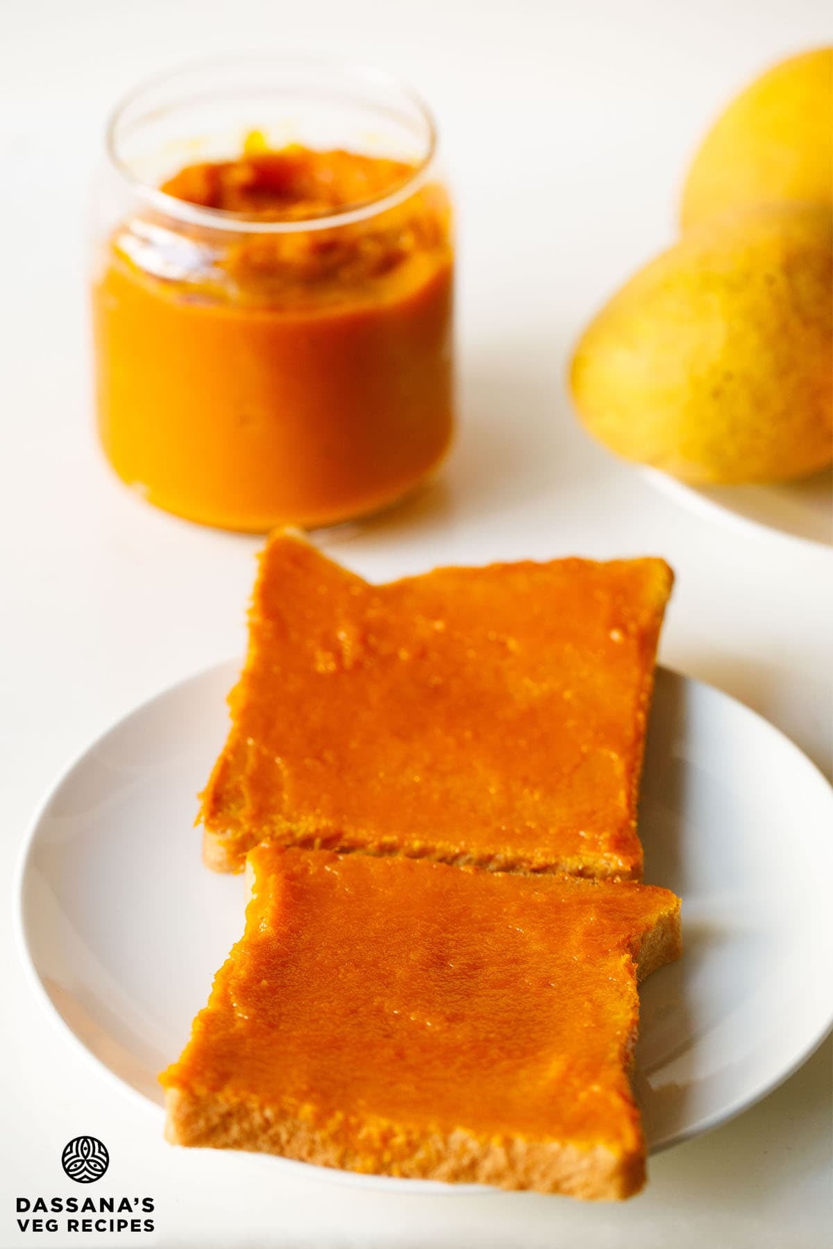 Toasts with mango jam and jar filled with homemade mango jam.