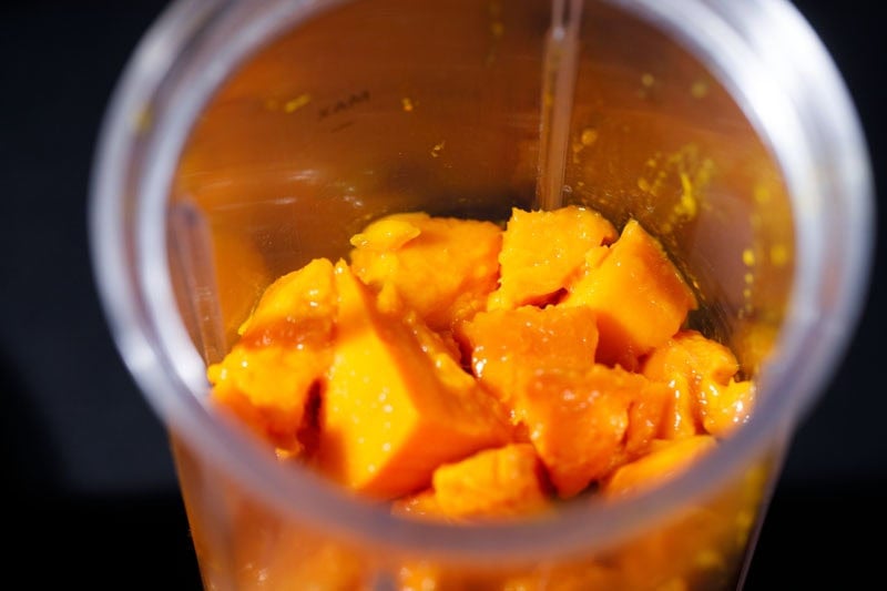 Chopped mango in a blender cup.