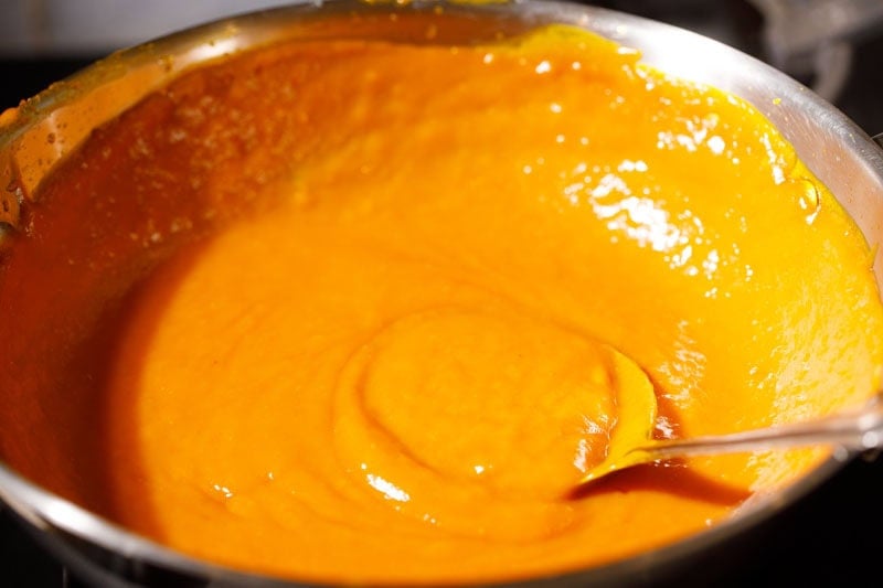 Thick mango puree simmering in pan.