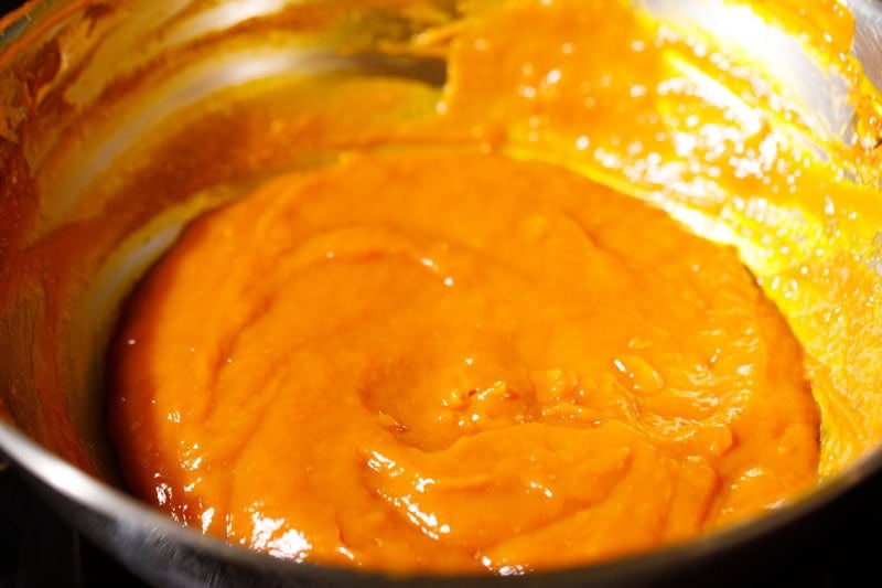 Thick mango puree cooking in pan.