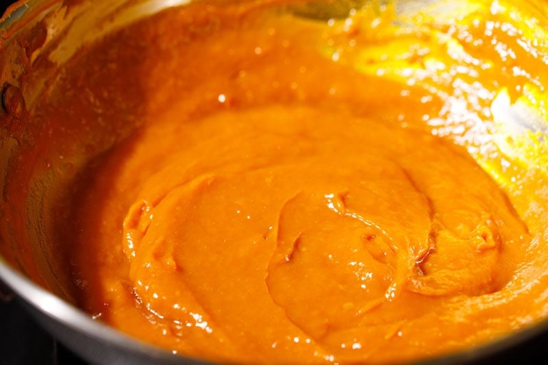 Thick mango puree simmering in pan.