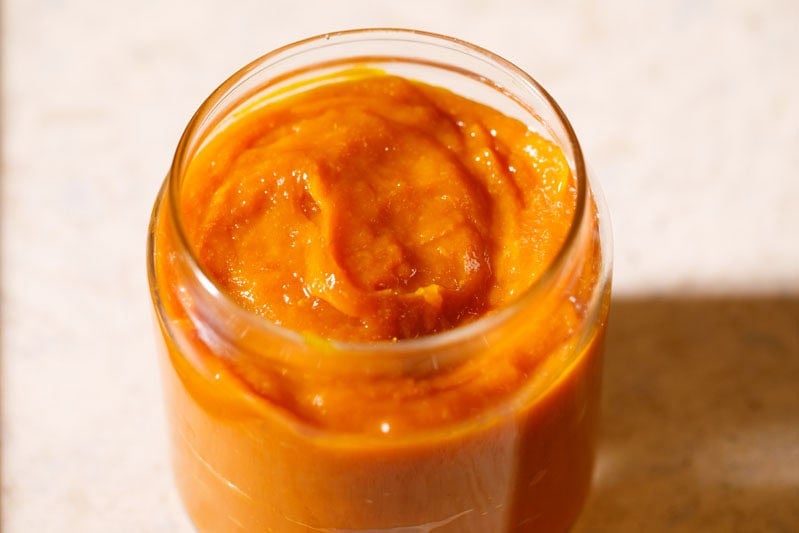 Jar filled with homemade mango jam.