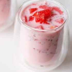 Pink colored Mohabbat ka sharbat in a glass topped with watermelon cubes.