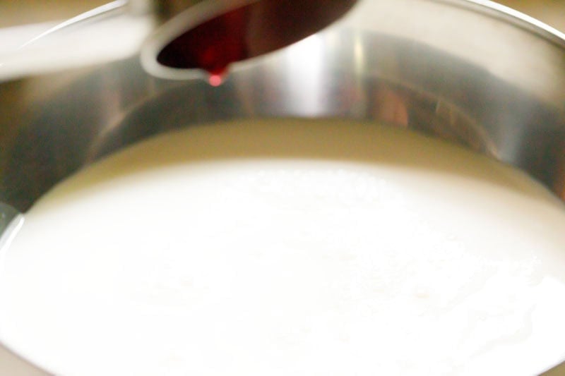 rooh afza being added to milk in bowl.