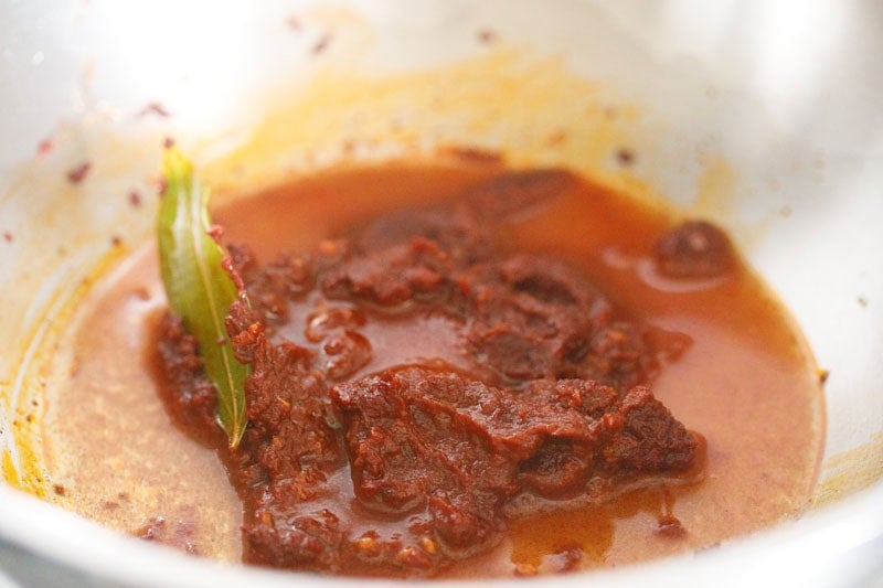 water and seasoned tomato paste in pan.