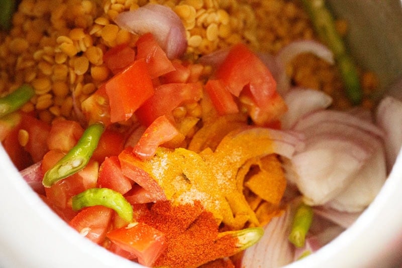 Ground spices and ingredients for toor dal in cooker.