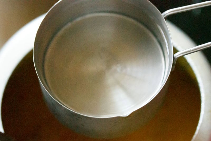 Measuring water with a metal cup.
