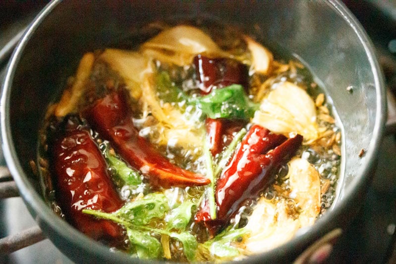 Spices and herbs frying in oil.