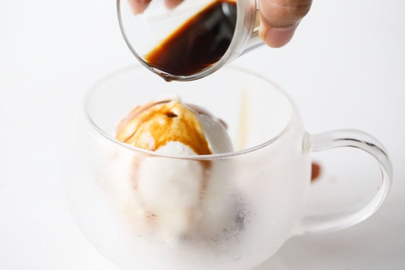 espresso being poured over vanilla ice cream.