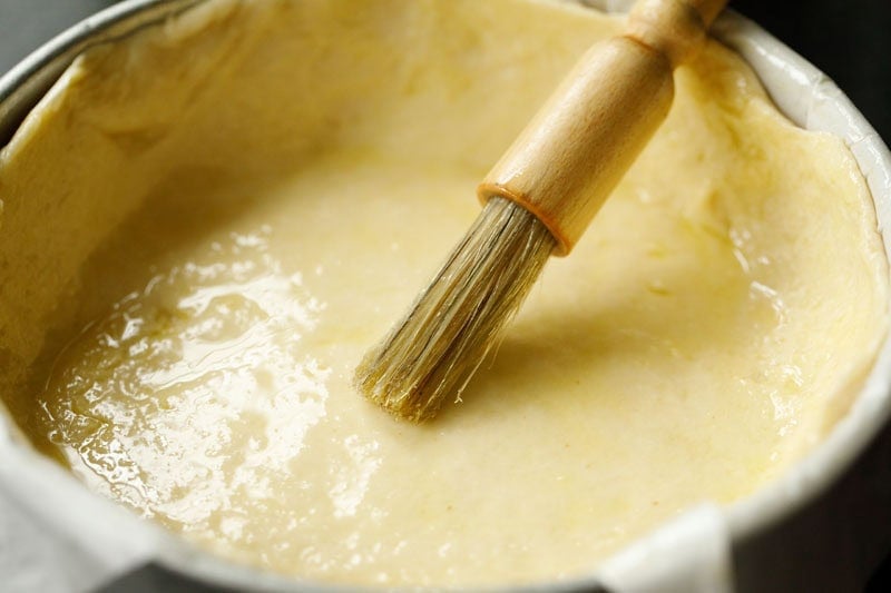 brushing olive oil on dough.