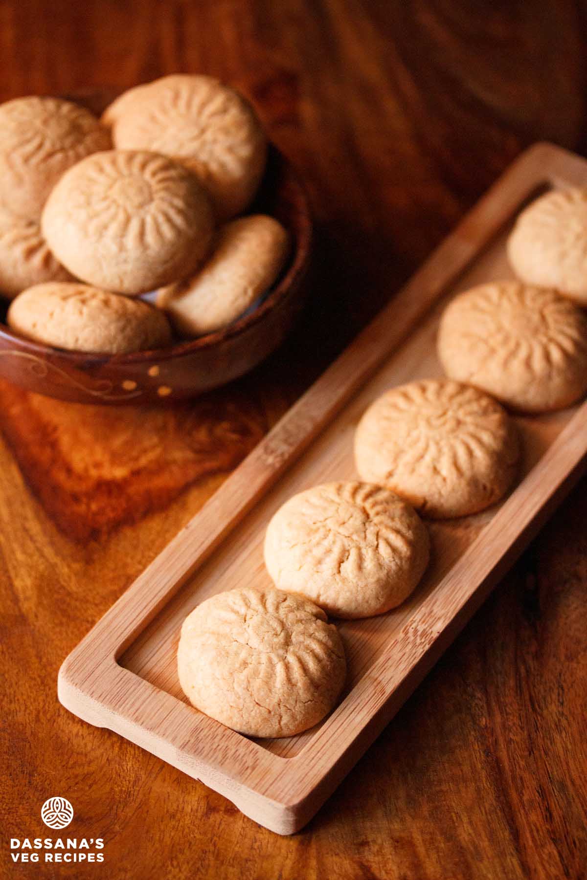 Neatly arranged atta biscuits on a wooden tray.