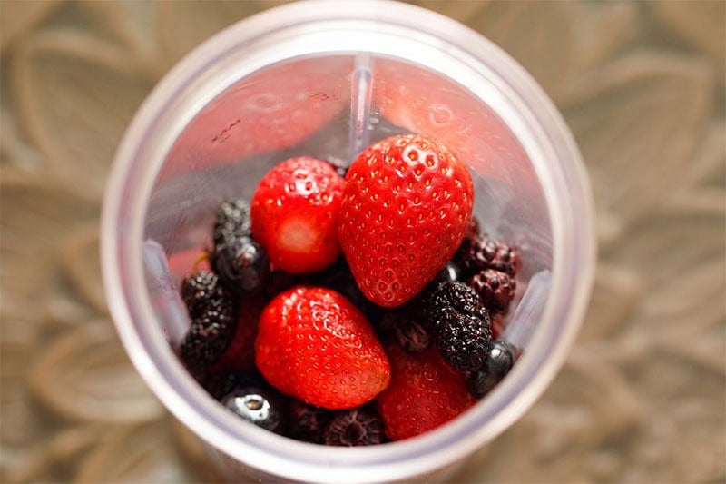 Fresh mixed berries in a blender cup.