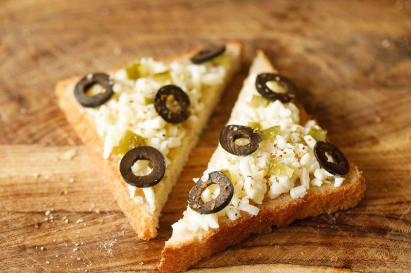 Rezept für Chili-Käse-Toast – Vegetarische Rezepte von Dassana 16 Brotscheiben mit Käse und Oliven belegt.