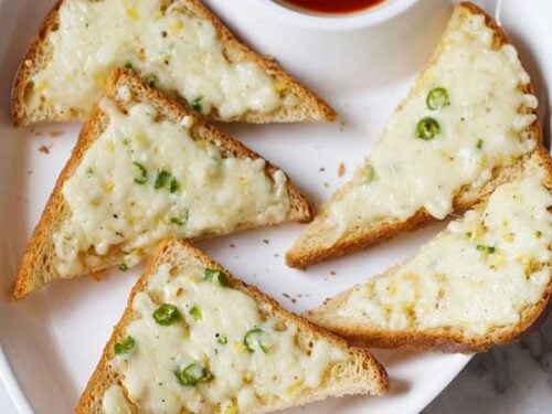 Chilli cheese toast on a white platter.