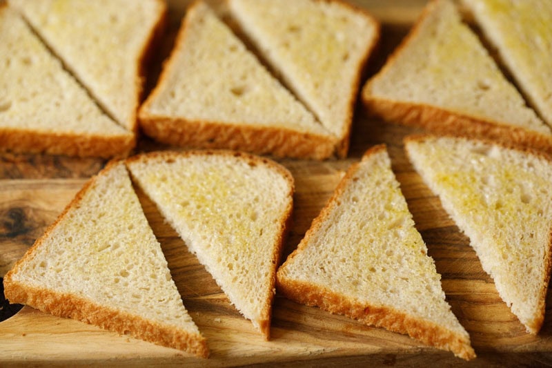 Rezept für Chili-Käse-Toast – Vegetarische Rezepte von Dassana 10 Dreieckige Brotscheiben, bestrichen mit zerlassener Butter.