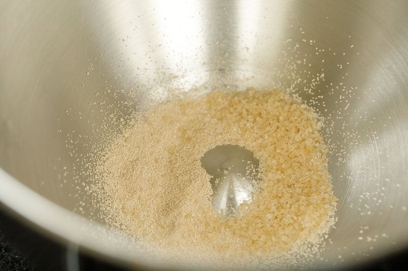 Instant yeast and sugar in stand mixer bowl.
