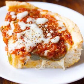 Slice of cheesy deep dish pizza.