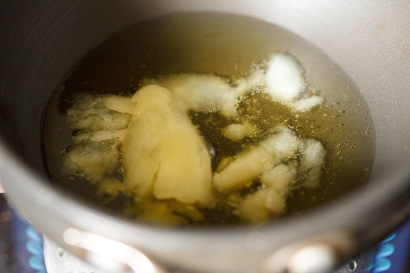 Ghee being heated in a small pan.