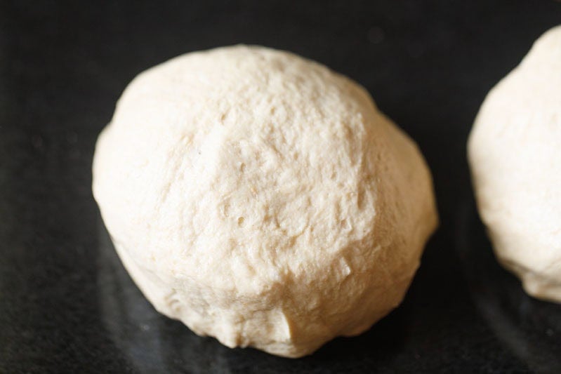 Raw dough ball on black surface.