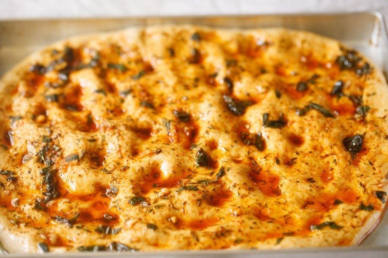 Herb-infused, unbaked focaccia bread.