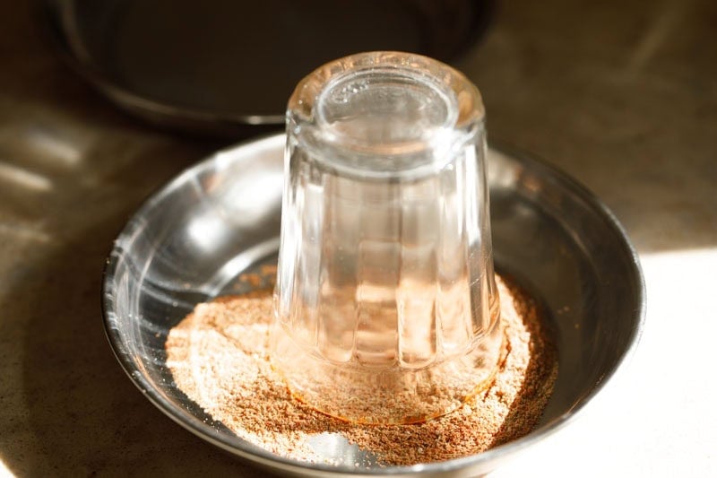 Shot glass on spice mixture on a plate.