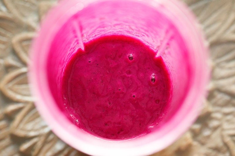 Smooth blended dark magenta color jamun drink in blender.